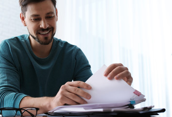 Man working with documents at table in office. Space for text