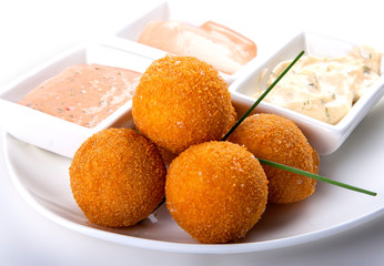 Fried cheese balls with sauce on a white background