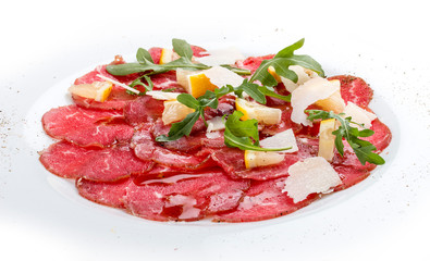 Veal carpaccio with arugula on white background