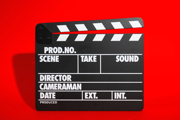 Fototapeta na wymiar Clapperboard on color background. Modern cinema production