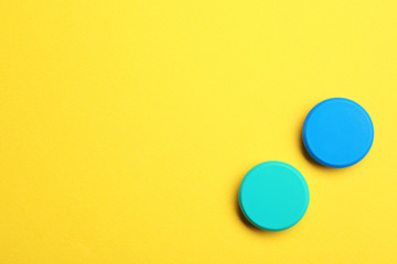 Bright magnets on color background, top view with space for text