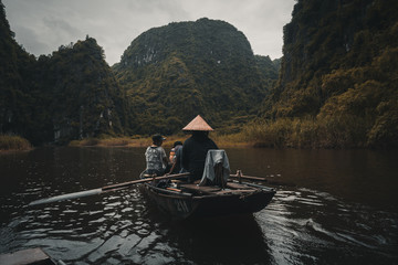 Woman rowing boat along a river in rural Vietnam
