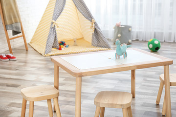 Cozy kids room interior with table, stools and play tent © New Africa