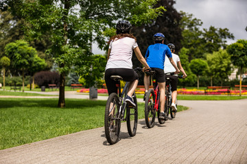 Healthy lifestyle - people riding bicycles in city park