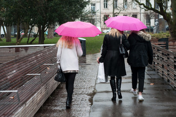 portrait of woman with pink umbrellas in urban park in the city on back view