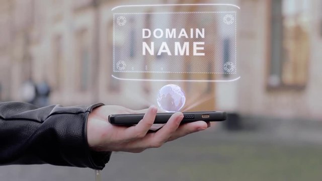 Male hands show on smartphone conceptual HUD hologram Domain name. Man with the future technology mobile holographic screen on blurred background of the university