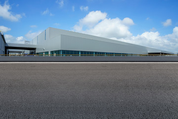 Road asphalt pavement and modern factory warehouse..