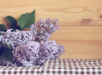 branch of purple lilac on the table,  place for text.