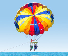 Happy couple Parasailing in Turkey beach in summer. Couple under parachute hanging mid air. Having...