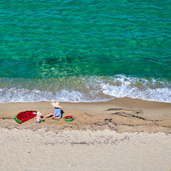 Boy and his mother on beach with inflatable float