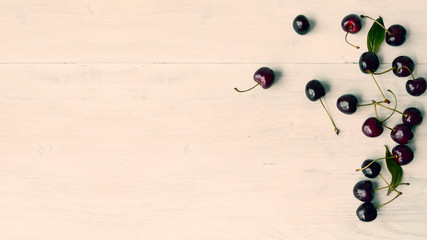 Summer food background - ripe cherry berries on white wooden table.