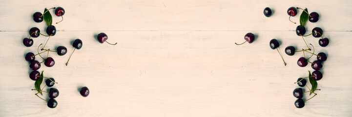 Summer food background - ripe cherry berries on white wooden table.Wide panoramic image.