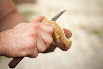 Raw potato peel, cook hands with knife