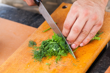 Greens chopping. Male hand with knife