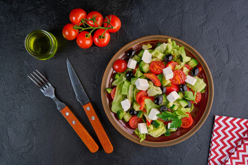 Greek salad with olives and feta on black background. Top view, flat lay