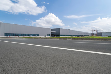 Road asphalt pavement and modern factory warehouse..