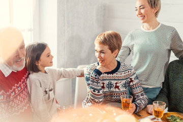 little adorable girl talking with her mother and aunt during the holiday. close up shot