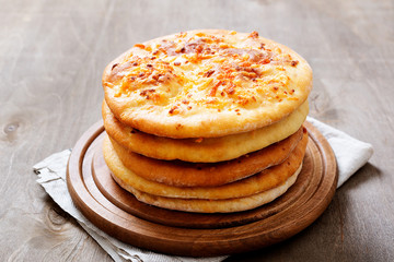 Freshly baked khachapuri with cheese on a wooden table.