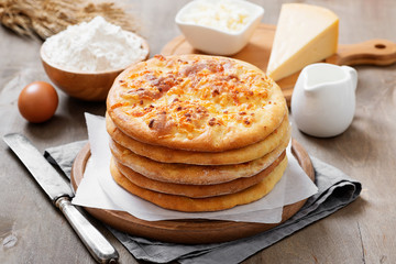 Freshly baked khachapuri with cheese on a wooden table.
