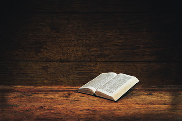 Bible on a old wooden table background.