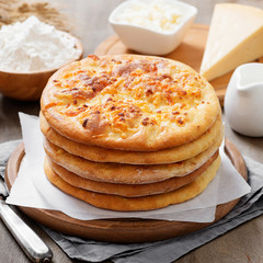 Freshly baked khachapuri with cheese on a wooden table.