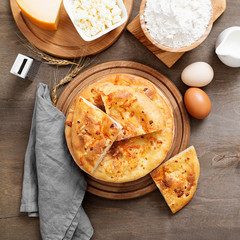 Freshly baked khachapuri with cheese on a wooden table.