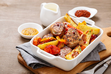Pork meat medallions with baked potatoes and cream sauce .