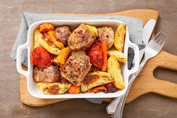 Pork meat medallions with baked potatoes and cream sauce .