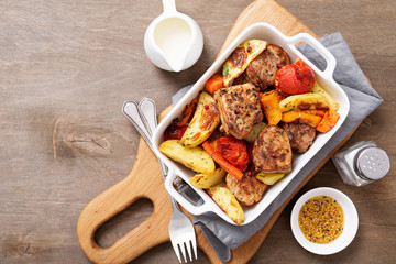 Pork meat medallions with baked potatoes and cream sauce .