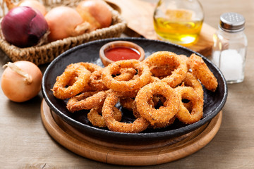 Delicious golden battered, breaded and deep fried crispy onion rings with ketchup.