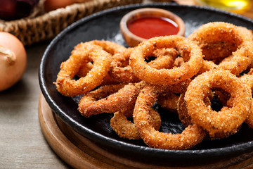 Delicious golden battered, breaded and deep fried crispy onion rings with ketchup.