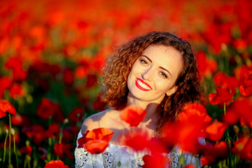 Beauty blue eyes teen enjoy summer days .Cute fancy dressed girl in poppy field. Field of blooming poppies.