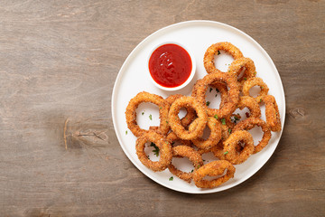 Delicious golden battered, breaded and deep fried crispy onion rings with ketchup.