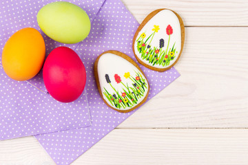 Easter background with Easter eggs . Easter gingerbread and eggs with purple napkin on wooden background.Easter Trend colors
