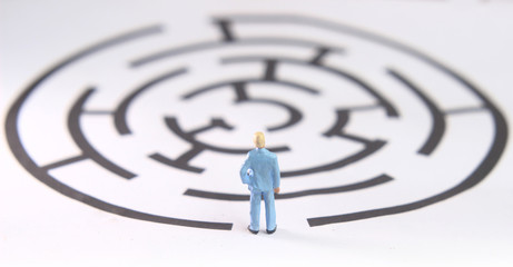 miniature figure toy young man prepare to walk into labyrinth, face the challenges to achieve goals