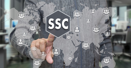 An elderly pensioner chooses SSC, service Center around the world on the touch screen on blur office background.