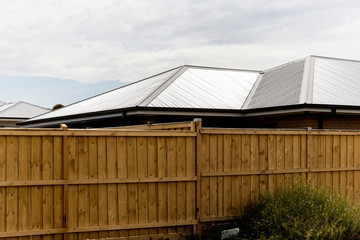 Fototapeta na wymiar Freshly installed steel colour roofing system. A common style in new Australian home. This type of material can withstand extreme weather conditons.