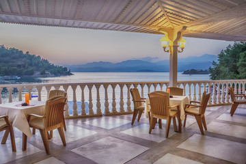 Tables and chairs in the restaurant terrace against the evening sky