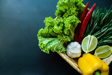 Fresh vegetables in a basket on a dark background. Proper nutrition. Side view.