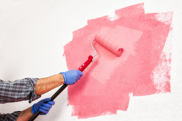 Professional house painter at work painting the wall © francescomou