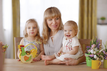 Mom and kids with colorful Easter eggs at the dinner table