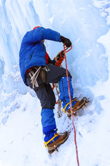 Fototapeta na wymiar rock climber screwing ice screw into glacier surface