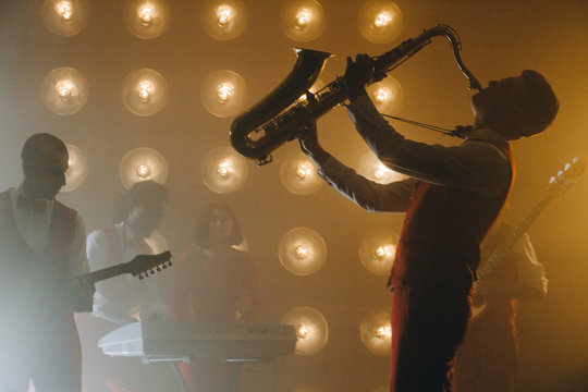 musician fully entertanced into his tunes. side view photo.simphonic night. pleasure from music