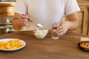 protein diet, healthy food, balanced proper nutrition, clean eating. overweight man eating cottage cheese for breakfast