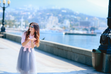Girl walking along the seafront in dress in hot summer day