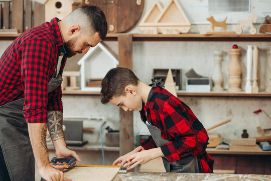 profession, carpentry, woodwork and family concept - carpentery masterclass for little children and their fathers to share basic knowledge of working with wood.