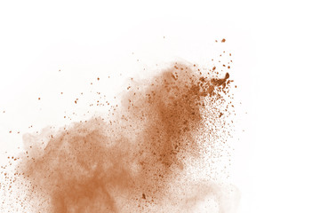 Brown color powder explosion on white background. Colored cloud. Colorful dust explode. Paint Holi.