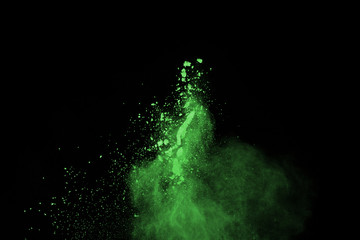 Fototapeta premium The movement of abstract dust explosion frozen green on black background. Stop the movement of powdered green on black background. Explosive powder green on black background.