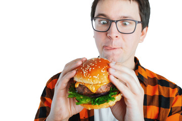 Young man holding a piece of hamburger. Student eats fast food. Burger is not helpful food. Very...
