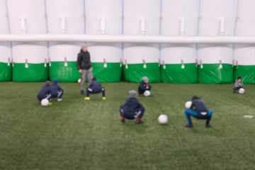 Obraz premium football training children. Football team of adorable boys exercising on green pitch on special facilities. blurry. Goalie training.
